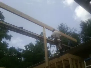 Carpenter setting a ridge beam over a new addition frame — Ice Dam Removal by Roofing Brothers in Rhinecliff