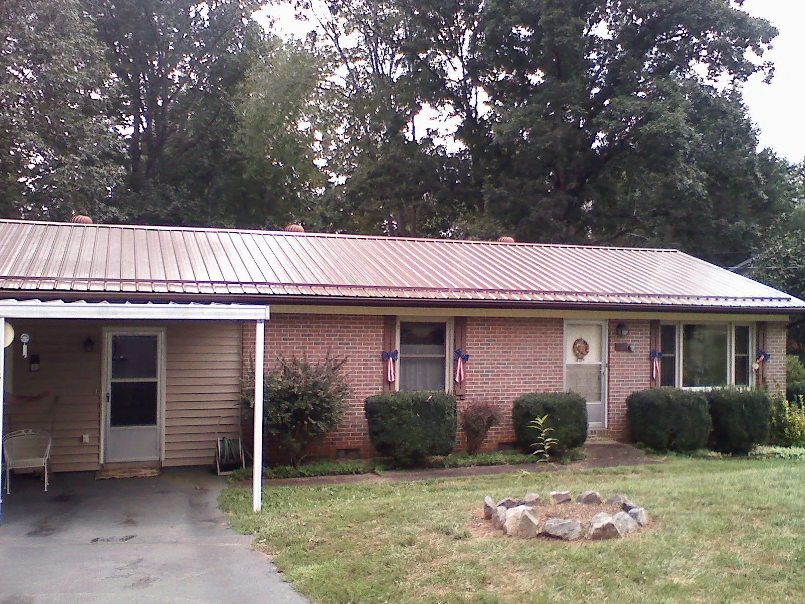 Bronze metal roof and carport on a brick ranch home — Roof Repair work by our crew in Rhinecliff