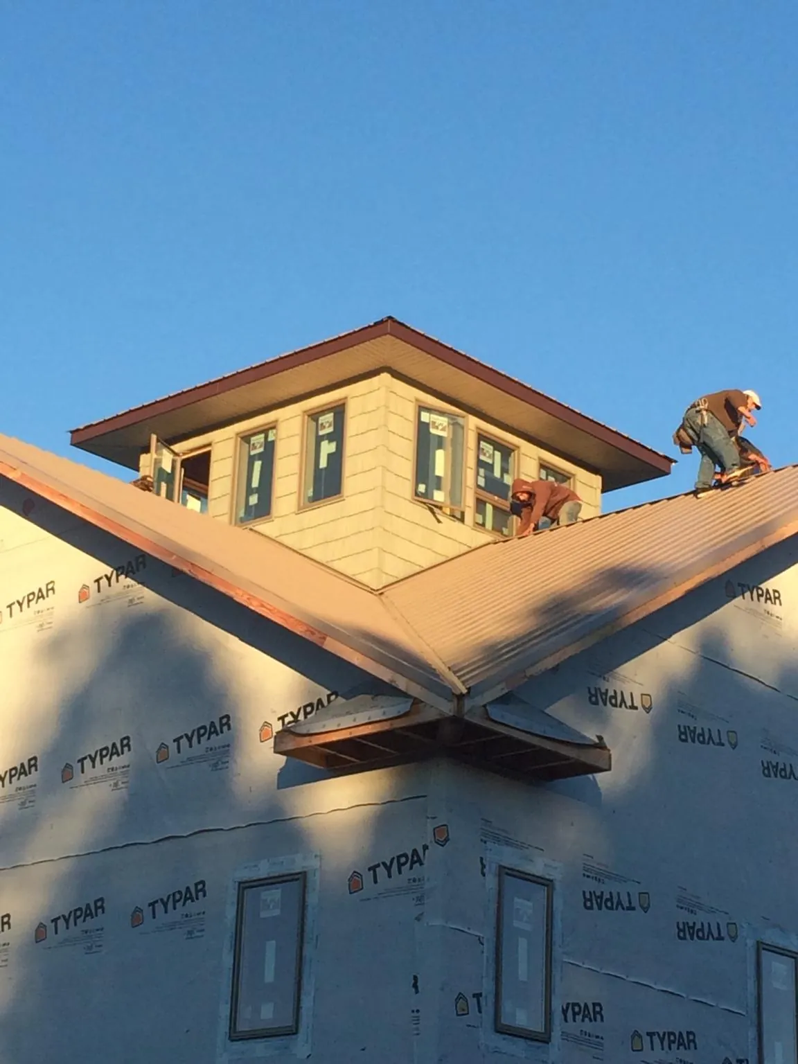 Roofers working around a rooftop cupola on a new metal roof at sunset — Roof Waterproofing in Rhinecliff by Roofing Brothers